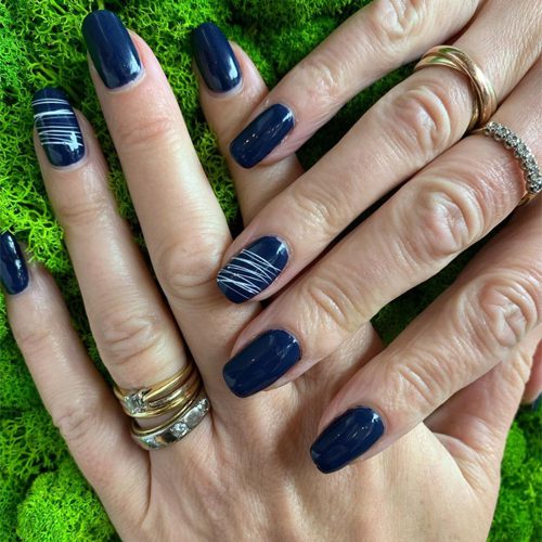 Dark blue nails with white nail art.